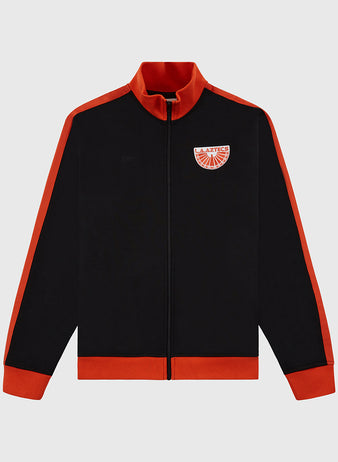 The Ebbets Field Los Angeles Aztecs Soccer Warm Up Jacket is black with red collar, cuffs, hem, and shoulder stripes. Features a NASL team emblem on the left chest, front zipper, and long sleeves for a sporty look.