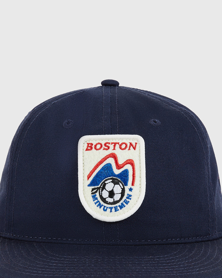 The Ebbets Field Boston Minutemen Cotton Twill Ballcap is navy blue with a white patch featuring 