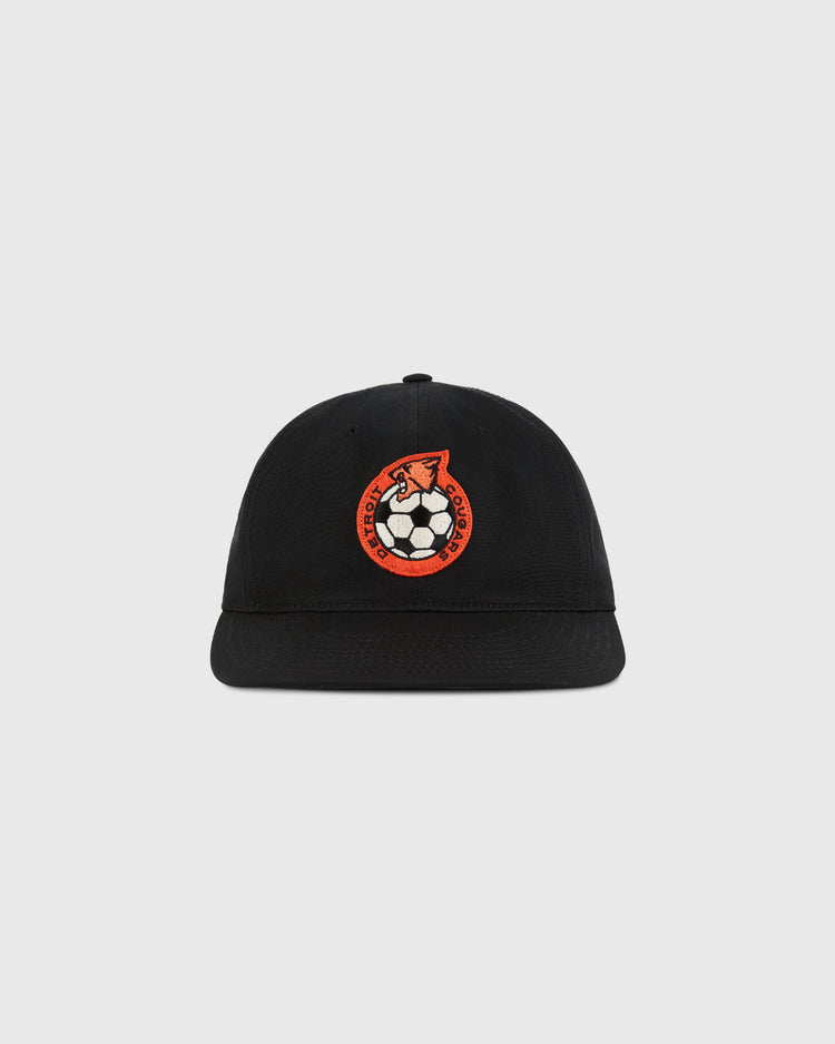 The Ebbets Field Detroit Cougars Cotton Twill Ballcap features a circular patch with an orange fox holding a soccer ball, inspired by classic NASL style, on black cotton twill with a plain light gray background.