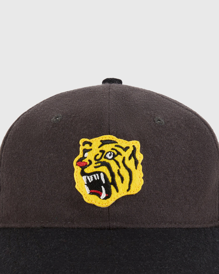 A close-up of the Ebbets Field Osaka Tigers 1940 Wool Ballcap in youth size, showing a black cap with an embroidered yellow and black snarling tiger head with a red mouth on the front against a plain light background.