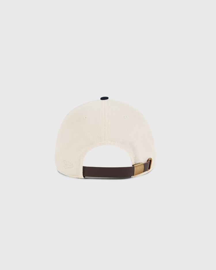 The Sam Adams Crest Cotton Twill Ballcap by Ebbets Field is shown from the back on a plain white background, featuring beige cotton twill, an adjustable brown strap with gold buckle, and an opening above the strap.