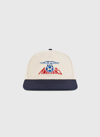 The Ebbets Field New Jersey Americans A-Frame Cotton Twill Ballcap features a beige crown, navy brim, blue eagle, and red AMERICANO text—a retro snapback inspired by the classic New Jersey Americans hat.