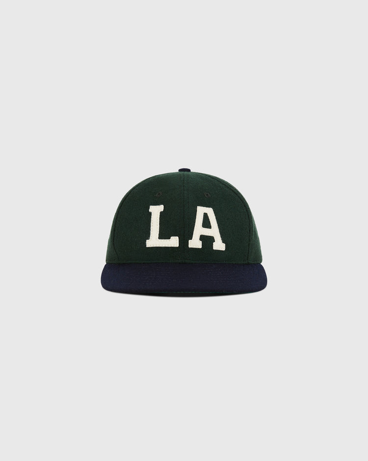 The Ebbets Field Los Angeles Angels (PCL) 1949 Wool Ballcap features a green crown, dark blue brim, and bold white LA letters on the front, echoing classic Pacific Coast League style, shown against a simple light background.