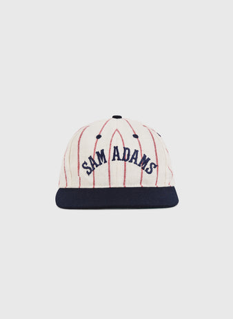 The Ebbets Field Sam Adams Pinstripe Wool Ballcap features cream wool with thin red pinstripes, a navy brim, and 