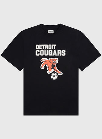 Show your soccer pride with the Detroit Cougars Short Sleeve Graphic T-Shirt by Ebbets Field—a black tee featuring bold white DETROIT COUGARS text above an orange cougar pouncing on a soccer ball.