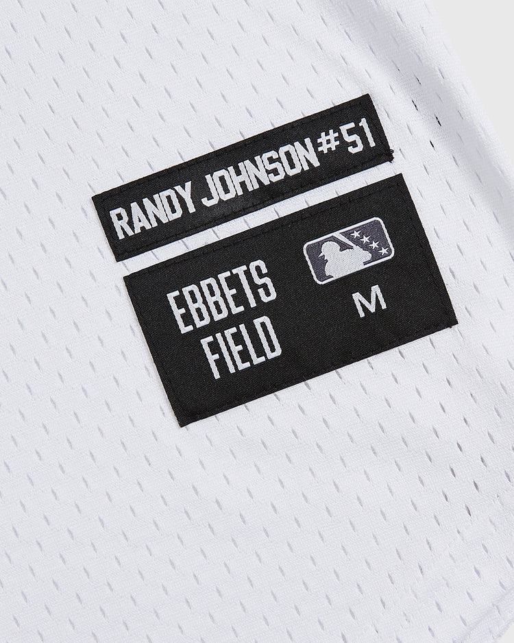Show your team spirit with the Ebbets Field Randy Johnson El Paso Diablos Button Up Mesh Jersey, featuring white mesh fabric, black RANDY JOHNSON #51 labels, an official Major League Baseball logo, and size M—an ideal choice for any El Paso Diablos fan or collector seeking an authentic Randy Johnson jersey.