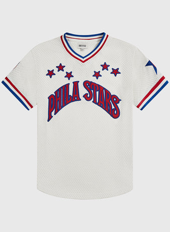 The Ebbets Field Philadelphia Stars V-Neck Mesh Jersey features a white mesh design with PHILA STARS in blue and red across the front, complemented by red and blue trim on the sleeves and collar, plus blue stars surrounding the text and on the left sleeve—honoring the classic Negro National League jersey style.
