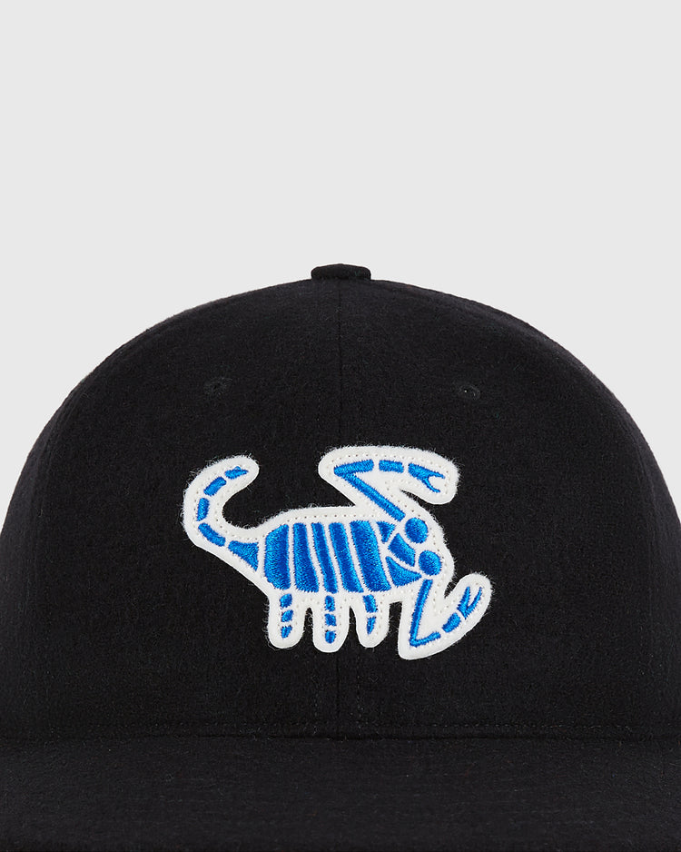 The Almendares Alacranes 1948 Authentic Wool Ballcap by Ebbets Field is a black wool cap featuring a blue and white embroidered scorpion design on the front.