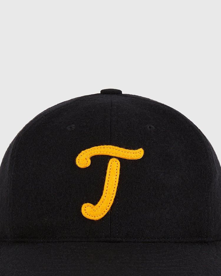 A close-up of the Ebbets Field Mexico City Tigres 1959 Authentic Wool Ballcap, a black cap with a large yellow letter T embroidered on the front center.