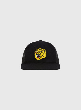 The Ebbets Field Osaka Tigers Wool Mesh Trucker Ballcap is shown on a plain light gray background, featuring a yellow roaring tiger head embroidered on the front of its black mesh design.
