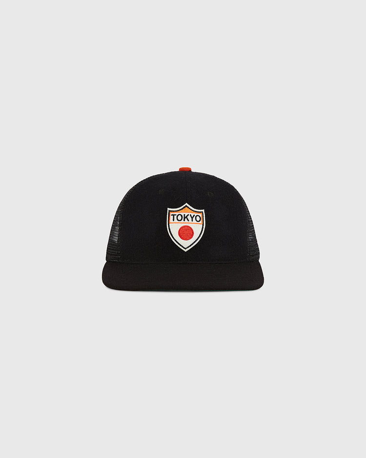 The Ebbets Field Tokyo Giants Wool Mesh Trucker Ballcap is a black vintage baseball cap with a flat brim, featuring a front patch that displays 