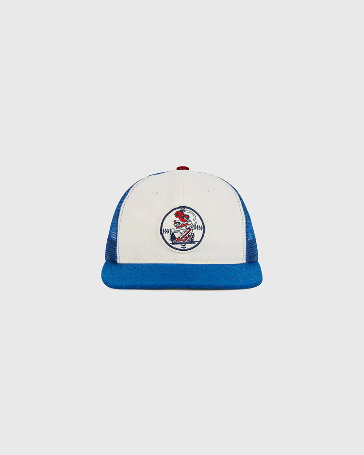 An Ebbets Field Nashville Sounds Mesh Trucker Ballcap in white and blue, featuring a red button on top and a circular baseball-themed patch with a red cardinal on the front, displayed against a plain light gray background.