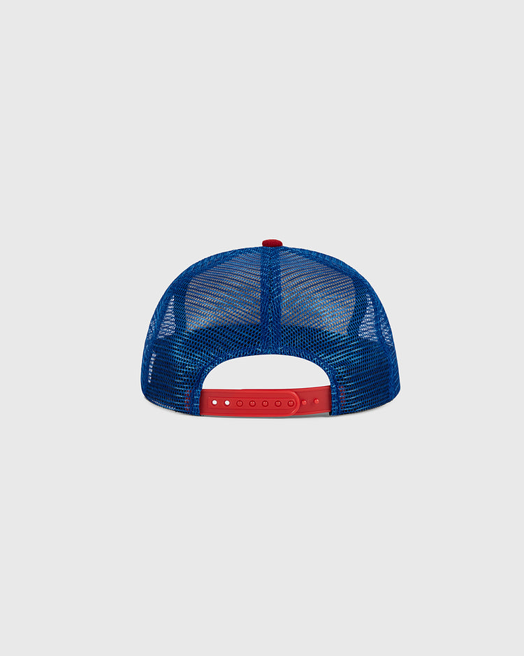The Santurce Wool Mesh Trucker Ballcap by Ebbets Field is shown from the back in blue mesh, with a red adjustable snapback closure and a small red button on top. The background is light gray.