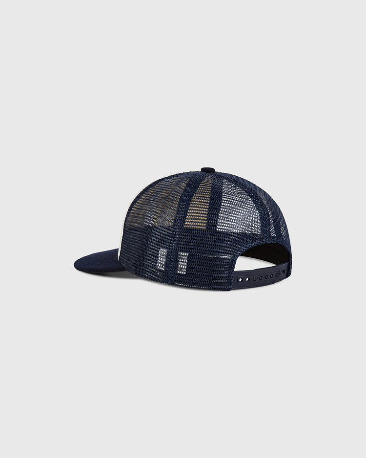 An Ebbets Field USA Wool Mesh Mesh Trucker Ballcap in navy blue is displayed from the back, highlighting its adjustable snapback closure and curved brim, set against a plain light gray background.