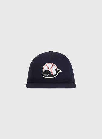 The Ebbets Field Taiyo Whales Cotton Twill Ballcap is a navy blue hat featuring a whale logo with baseball stitching on its body, displayed against a plain light gray background.