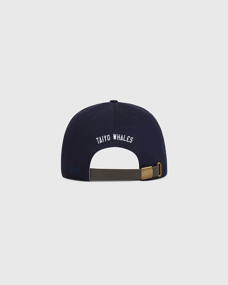 The Ebbets Field Taiyo Whales Cotton Twill Ballcap is displayed from the back, featuring “TAIYO WHALES” embroidered in white and an adjustable strap with a brass buckle.