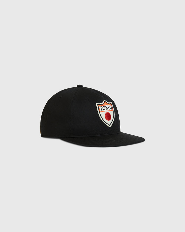 Ebbets Field Tokyo Giants Patch Cotton Twill Ballcap—a black baseball cap with a flat brim, featuring a red and white “Tokyo” patch above a red circle on the front—displayed against a plain light gray background.