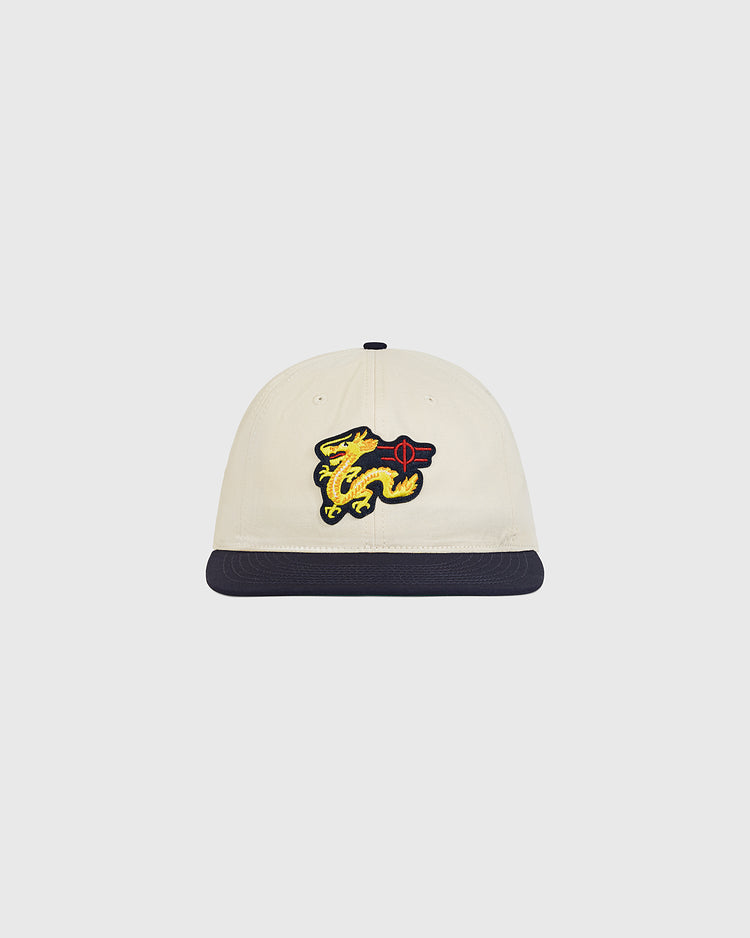 The Chunichi Dragons Cotton Twill Ballcap by Ebbets Field is a cream-colored vintage baseball cap with a dark brim, featuring an embroidered yellow dragon and red aim target emblem on the front—drawing classic style inspiration from iconic Chunichi Dragons ballcaps.