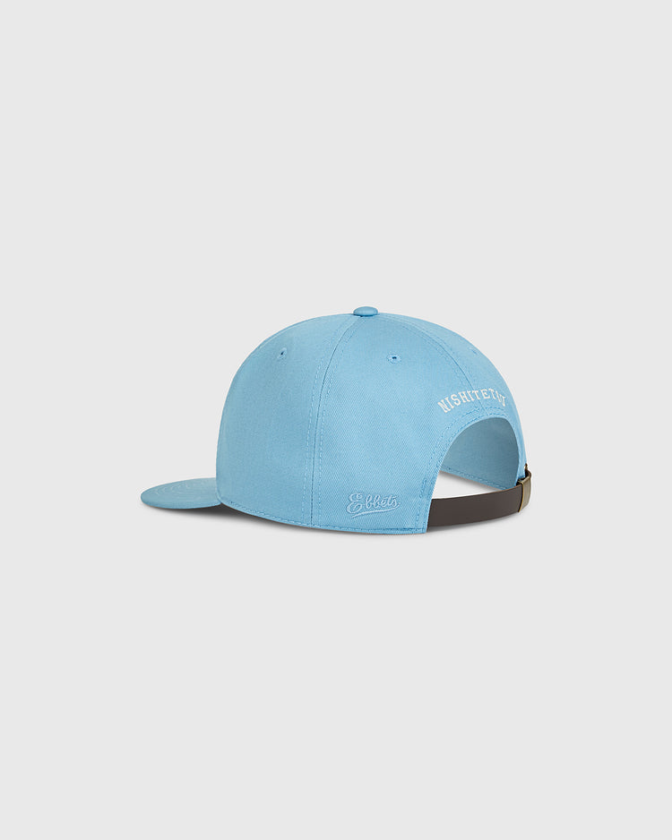 The Nishitetsu Lions 1971 Cotton Twill Ballcap by Ebbets Field is shown from the back, featuring white embroidered text and an adjustable brown strap with a metal clasp. The background is plain and light gray.