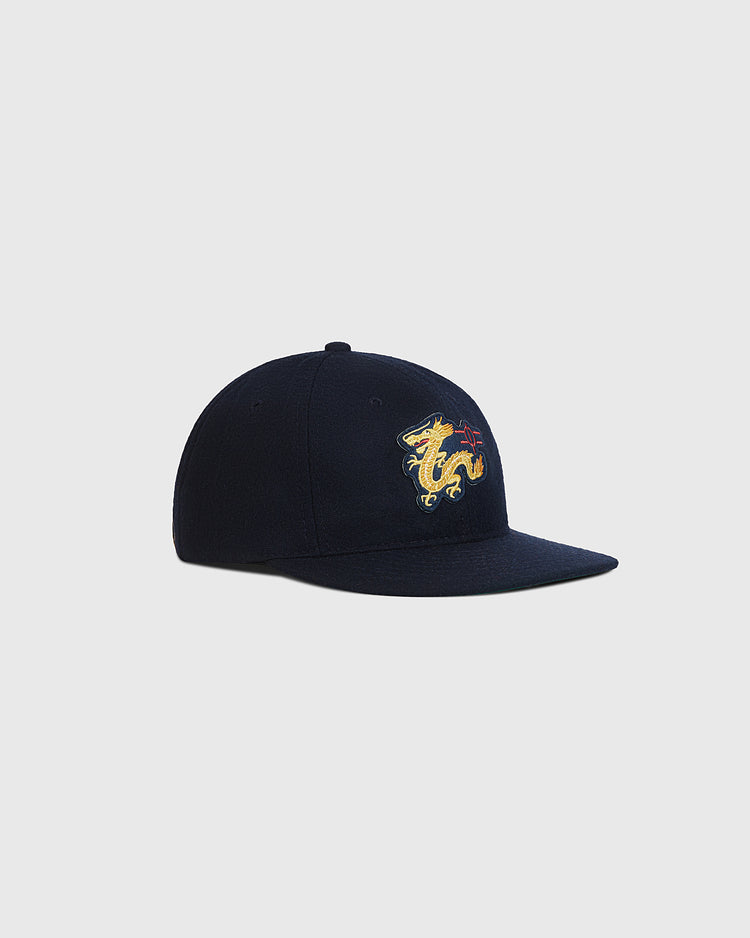 The Ebbets Field Chunichi Dragons 1969 Wool Ballcap is an authentic navy blue cap featuring an embroidered yellow dragon on the front, inspired by Central League championship tradition and shown against a plain light gray background.