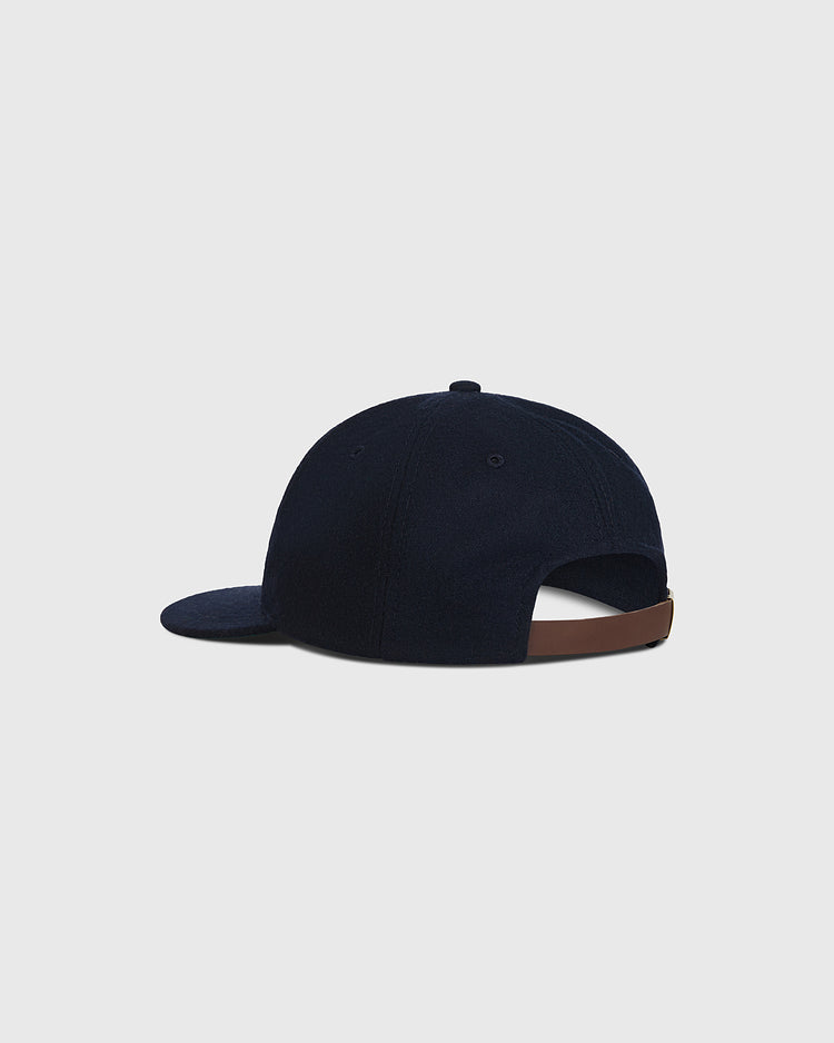 A Chunichi Dragons 1969 Wool Ballcap by Ebbets Field is displayed from the back, highlighting its brown adjustable strap and slightly curved brim against a plain light gray background. Crafted from authentic wool, this navy blue cap channels classic design while providing both comfort and timeless style.