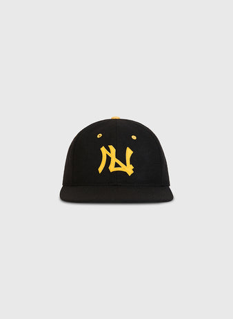 Ebbets Field Nishitetsu Lion 1971 Authentic Wool Ballcap in black wool with a flat brim, showcasing bold yellow embroidered lettering on the front—a tribute to the iconic style of the Nishitetsu Lions during their Fukuoka era. Set against a plain, light gray background.
