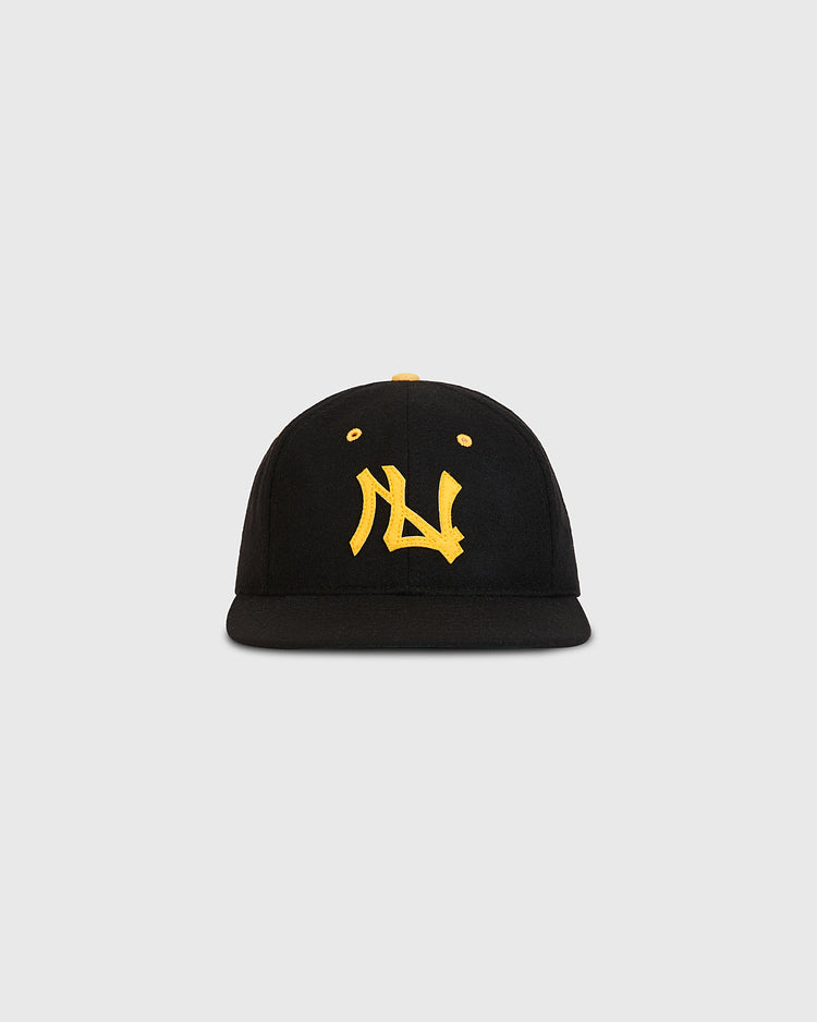 Ebbets Field Nishitetsu Lion 1971 Authentic Wool Ballcap in black wool with a flat brim, showcasing bold yellow embroidered lettering on the front—a tribute to the iconic style of the Nishitetsu Lions during their Fukuoka era. Set against a plain, light gray background.