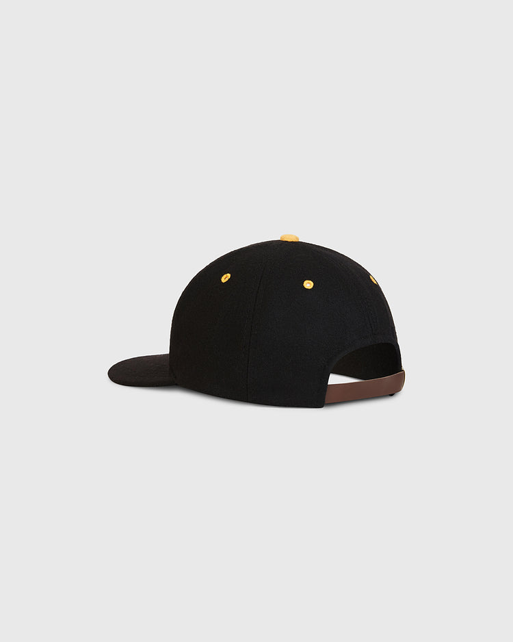 The Nishitetsu Lion 1971 Authentic Wool Ballcap by Ebbets Field is shown from the back, highlighting its black wool construction, yellow eyelets, and brown adjustable strap. Inspired by classic Fukuoka era designs, the cap is set against a simple light gray background.