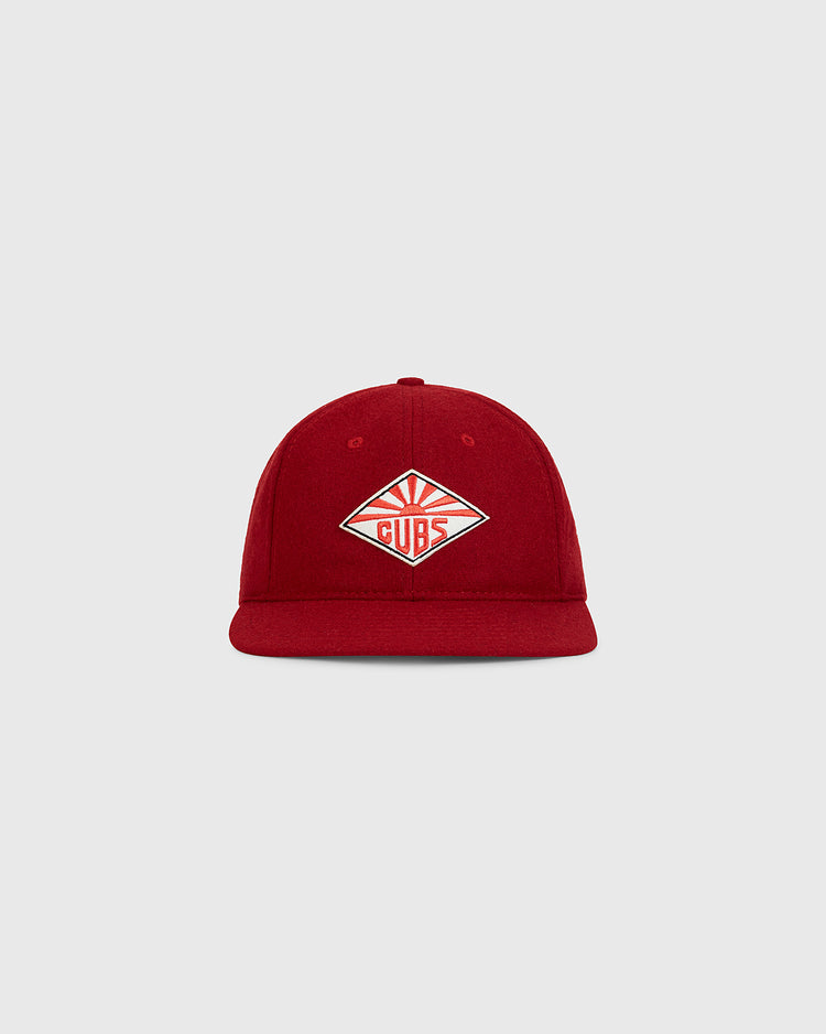 The Taiyo Cubs 1928 Authentic Wool Ballcap by Ebbets Field is a red cap displayed on a light gray background, featuring a diamond-shaped patch with “Cubs” and stylized sun rays on the front.