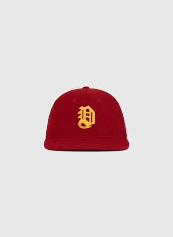 The Ebbets Field Daiei Stars 1949 Authentic Wool Ballcap—a red cap featuring a yellow embroidered letter D on the front—is displayed against a plain light gray background, making it an ideal piece for collectors of Japanese baseball memorabilia and fans of classic vintage headwear.