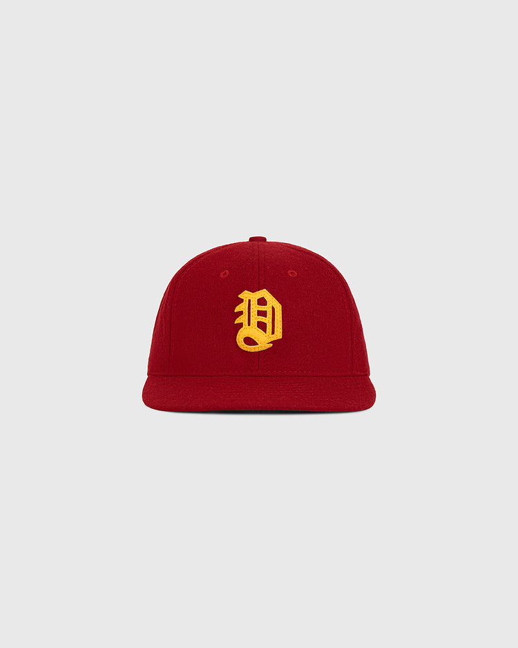 The Ebbets Field Daiei Stars 1949 Authentic Wool Ballcap—a red cap featuring a yellow embroidered letter D on the front—is displayed against a plain light gray background, making it an ideal piece for collectors of Japanese baseball memorabilia and fans of classic vintage headwear.