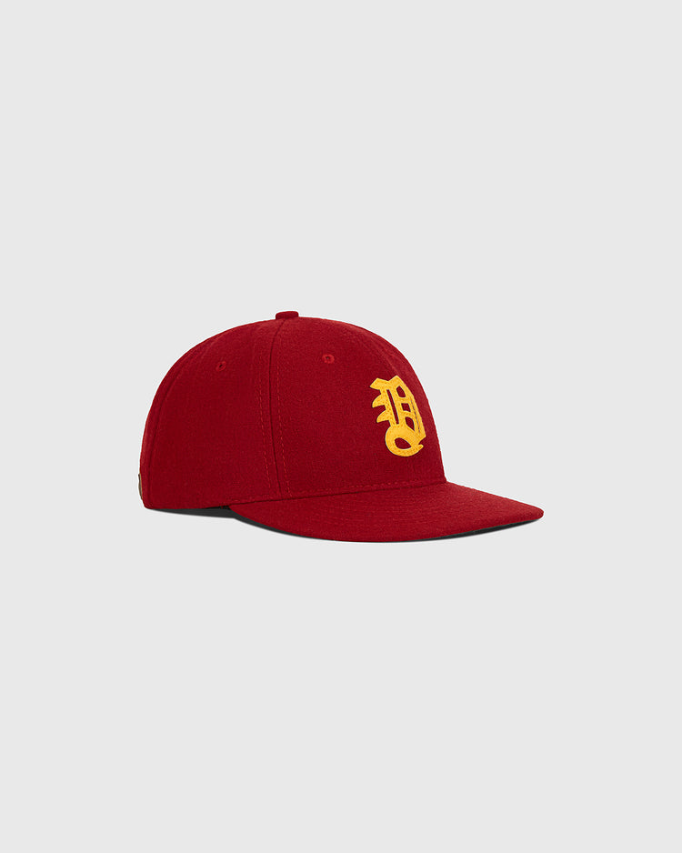 A Daiei Stars 1949 Authentic Wool Ballcap by Ebbets Field, featuring a rich red wool construction with a curved brim and a yellow embroidered letter B on the front, inspired by classic Japanese baseball memorabilia like the original 1949 Daiei Stars cap, shown against a plain light gray background.