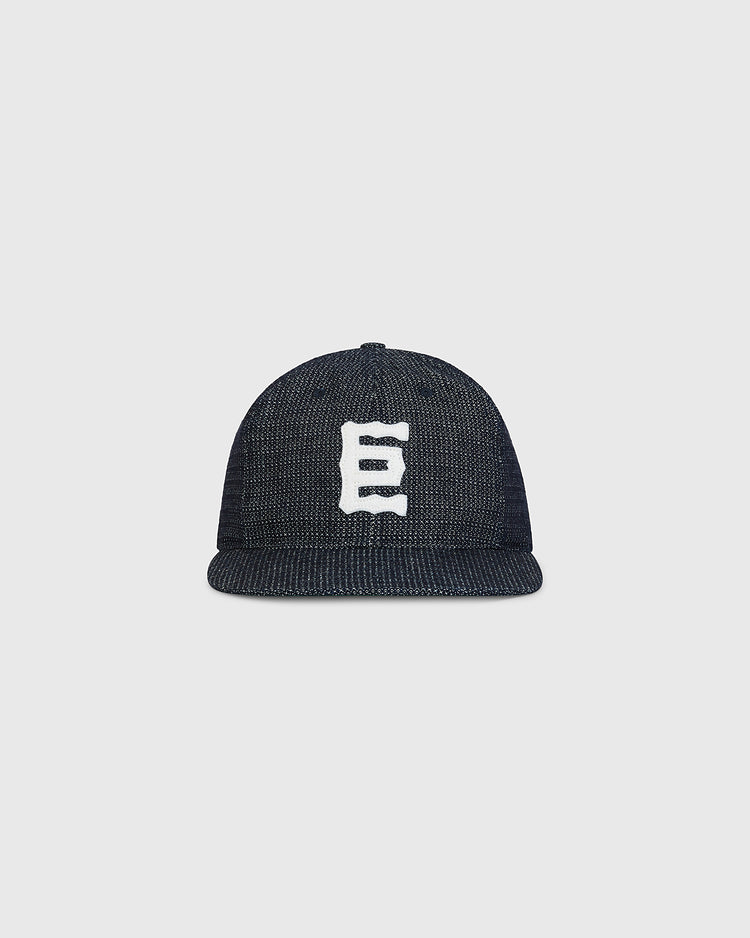 An Ebbets Field Tokyo Giants 1940 Japanese Indigo Cotton Ballcap, featuring a white, stylized letter E on the front, is displayed against a plain light gray background.