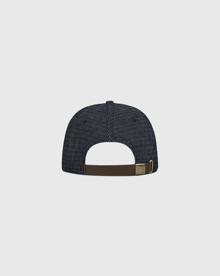 The Ebbets Field Hiroshima Carp Japanese Indigo Cotton Dobby Ballcap is shown from the back, highlighting its deep blue textured Japanese cotton fabric and a brown adjustable strap with a metallic buckle against a plain light background.