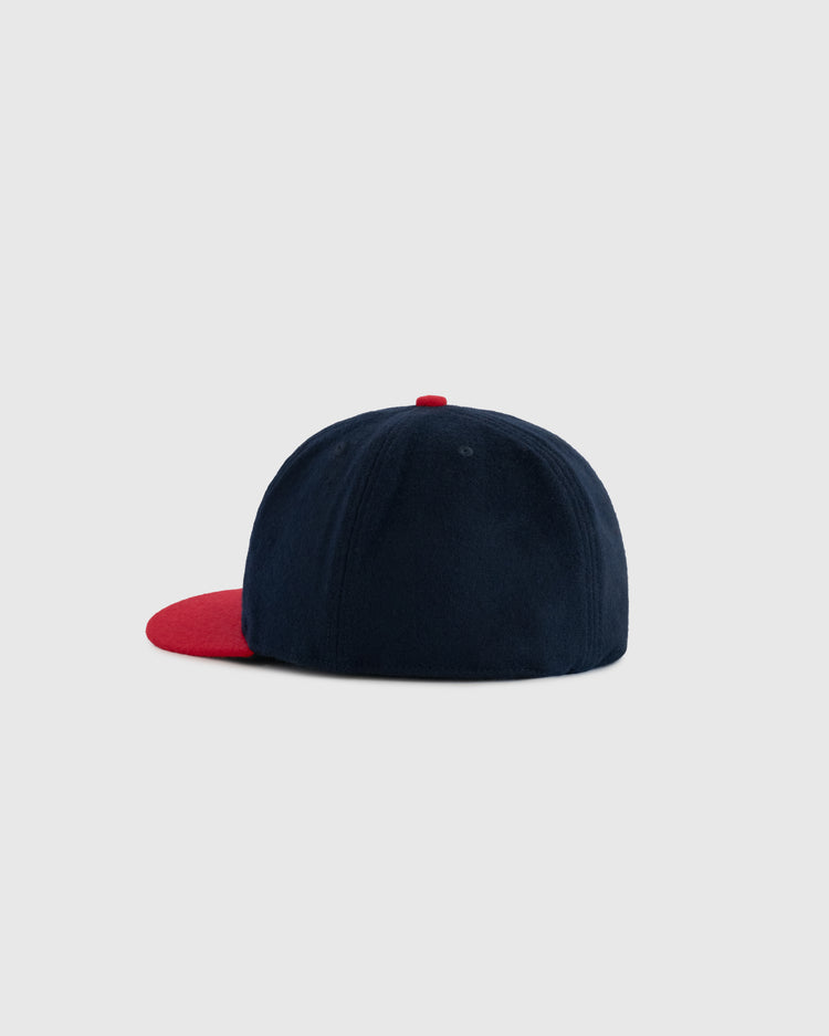 The back of an EFF Rochester Red Wings 1950 Authentic Wool Ballcap, featuring navy blue wool and a red brim, is displayed against a plain light gray background.