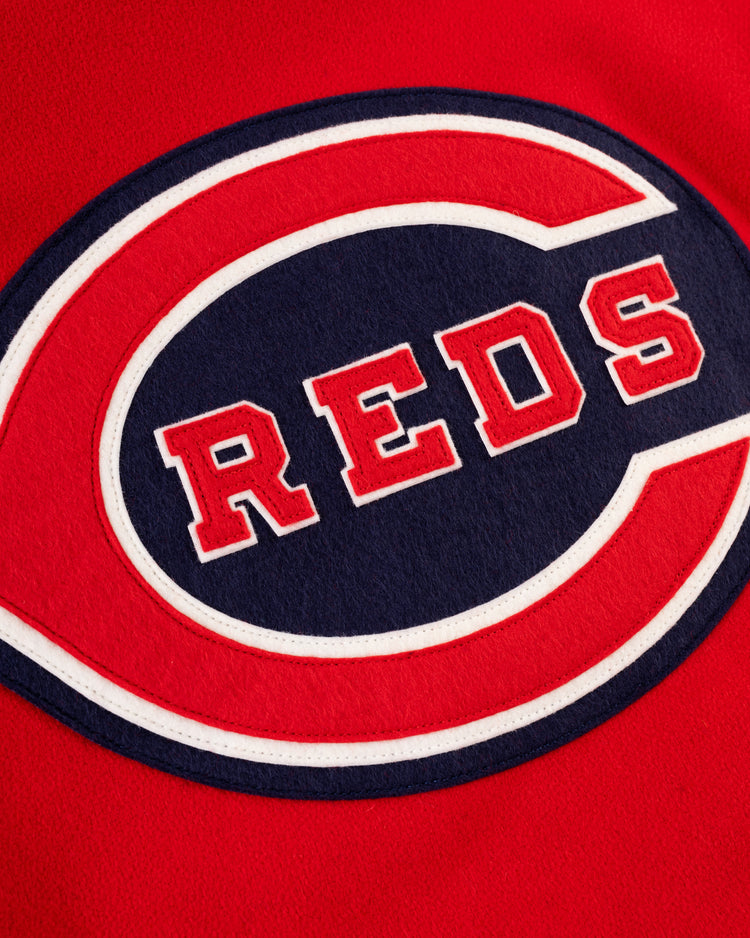 A close-up of the EFF Cincinnati Reds 1940 Authentic Wool & Leather Jacket shows vibrant red fabric with a large white and blue embroidered C, encircling bold red REDS lettering outlined in white.