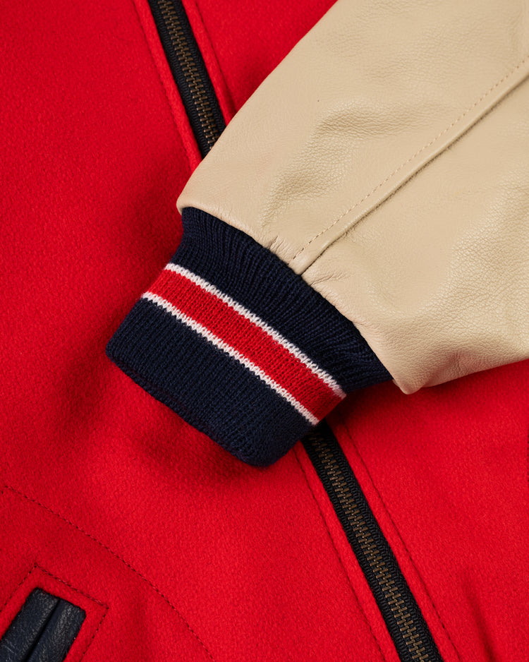 Close-up of the EFF Cincinnati Reds 1940 Authentic Wool & Leather Jacket, showing its red wool body, beige leather sleeve, navy/red/white striped knit cuff, black zipper, and pocket detail.