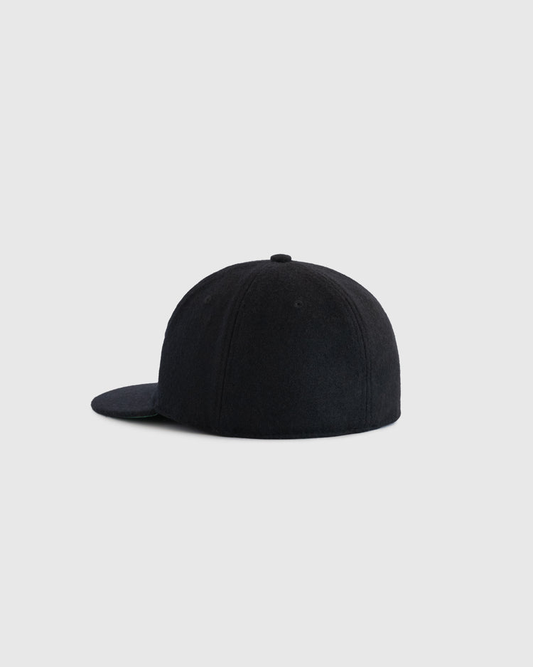 The EFF Tombow Unions 1955 Authentic Wool Ballcap in black is shown from the back at an angle on a plain light gray background. The flat brim and minimalist design evoke classic Japanese baseball history.