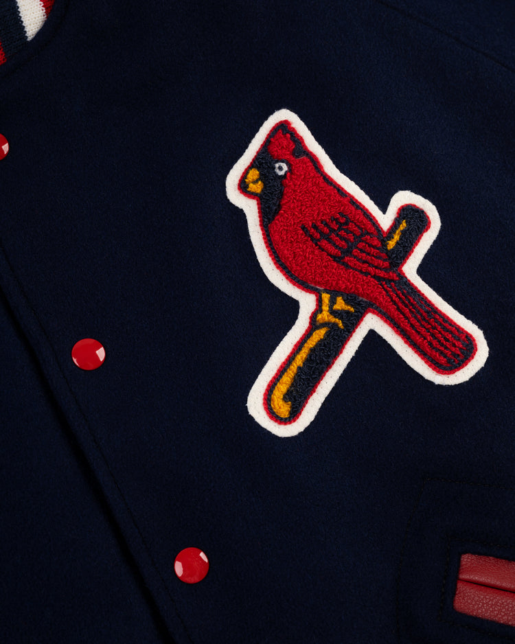 A close-up of the EFF St. Louis Cardinals 1950 Authentic All Wool Varsity Jacket, showcasing a red cardinal bird patch on a yellow bat, red buttons, and a partially visible striped collar.