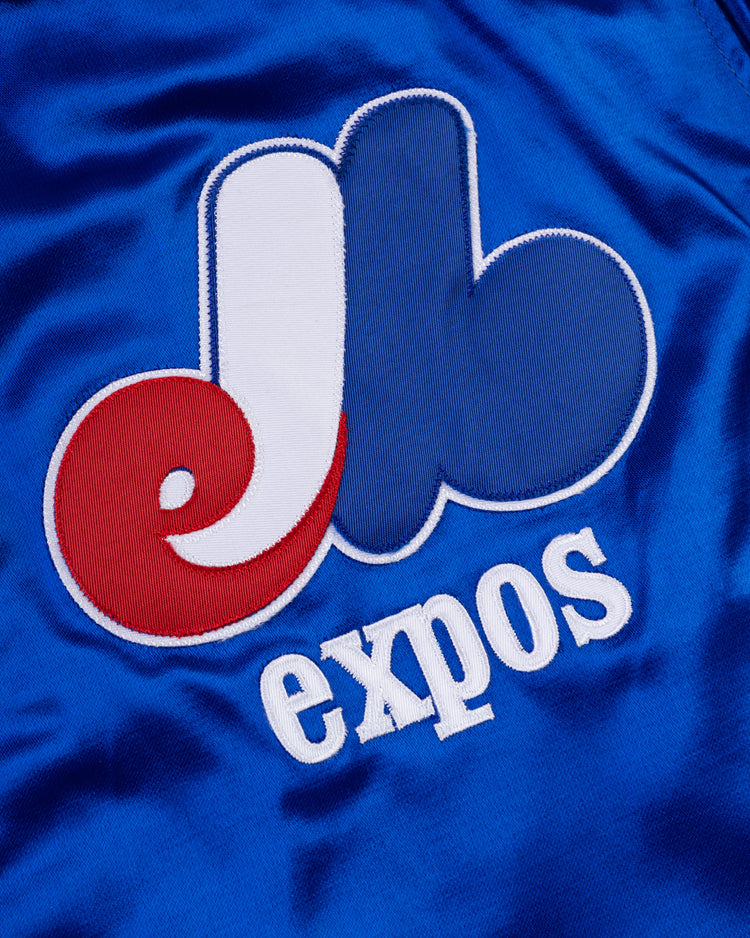Close-up of the EFF Montreal Expos 1969 Authentic All Satin Varsity Jacket: features the classic red, white, and blue eb logo on shiny blue satin with expos stitched below—a timeless tribute to the team’s original style.
