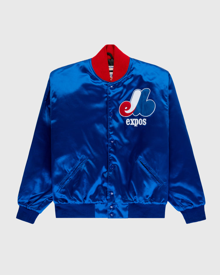 The EFF Montreal Expos 1969 Authentic All Satin Varsity Jacket features shiny blue satin, a red collar, team logo and expos on the left chest, front snap buttons, side pockets, and ribbed cuffs and hem.