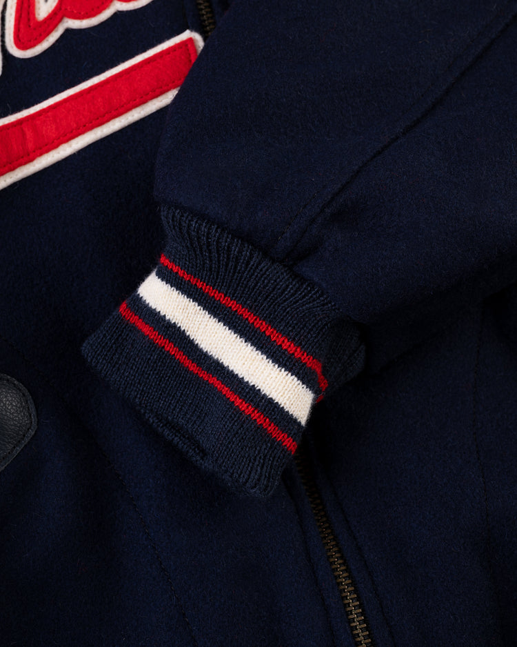 Close-up of the EFF Washington Senators 1966 Authentic All Wool Varsity Jacket sleeve with a ribbed cuff in red, white, and navy stripes plus partial red and white embroidery near the zipper, reflecting classic team jacket style.