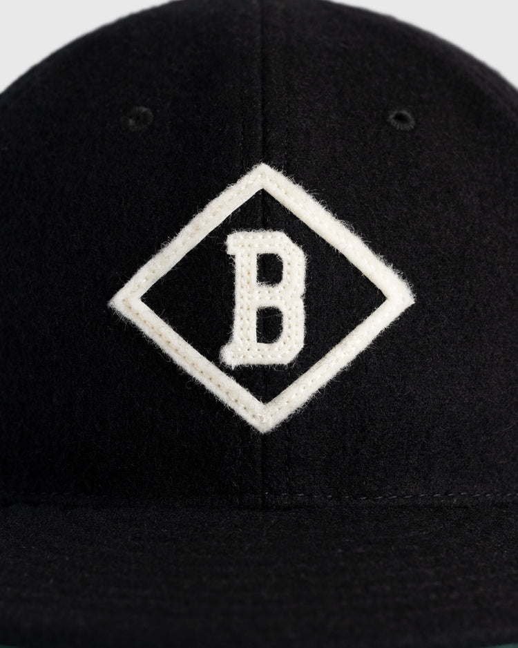 The Bismarck Churchills 1935 Authentic Wool Softbrim Ballcap by EFF is a black cap with a white diamond patch and bold B, inspired by the iconic 1935 baseball replica style.