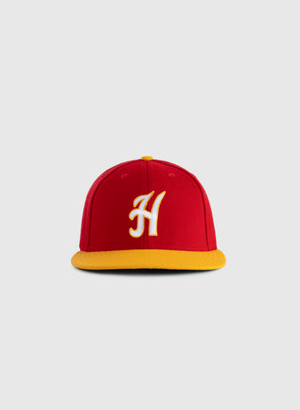 The EFF Hawaii Islanders 1986 Authentic Wool Ballcap features red wool serge, a yellow brim, and a white embroidered H on the front, inspired by the 1986 logo and shown on a plain gray background.