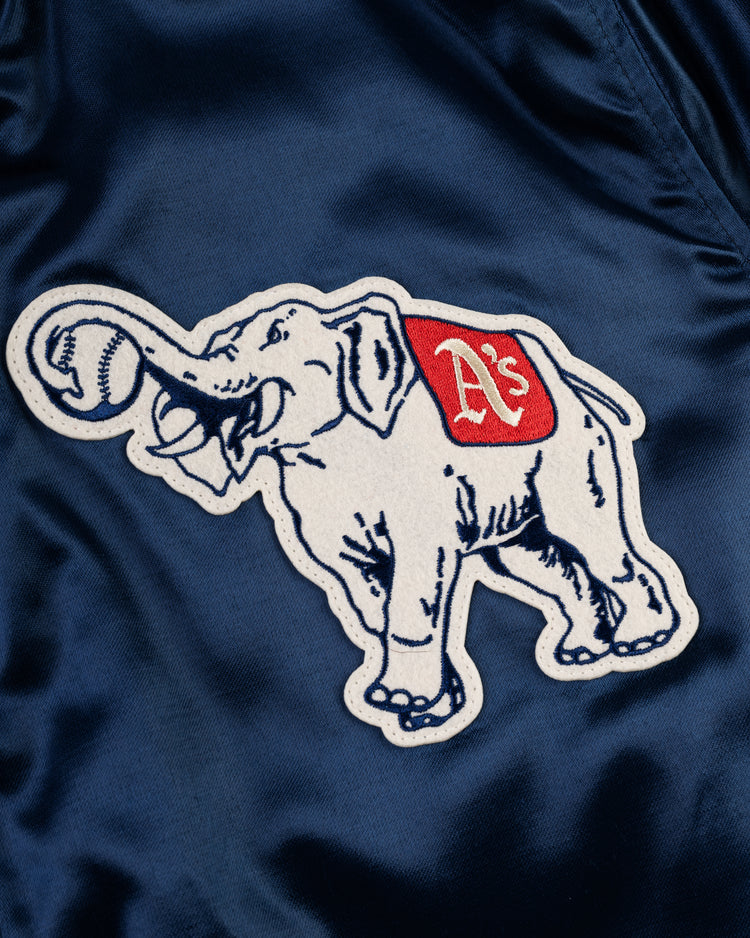 A white elephant patch with a red As blanket, holding a baseball, is sewn onto a blue EFF Philadelphia Athletics 1953 Authentic All Satin Varsity Jacket.