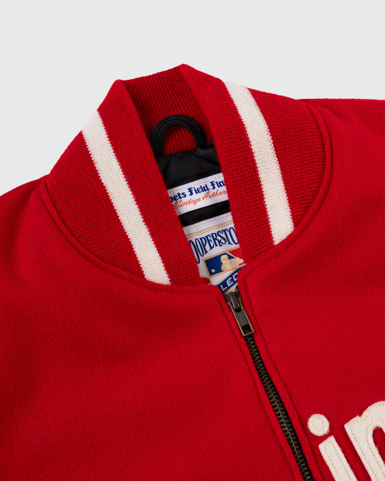 Close-up of the EFF Cincinnati Reds 1969 Authentic All Wool Varsity Jacket, showcasing its red body, white-striped ribbed collar, Cooperstown Collection label, partial zipper, and embroidered front lettering.