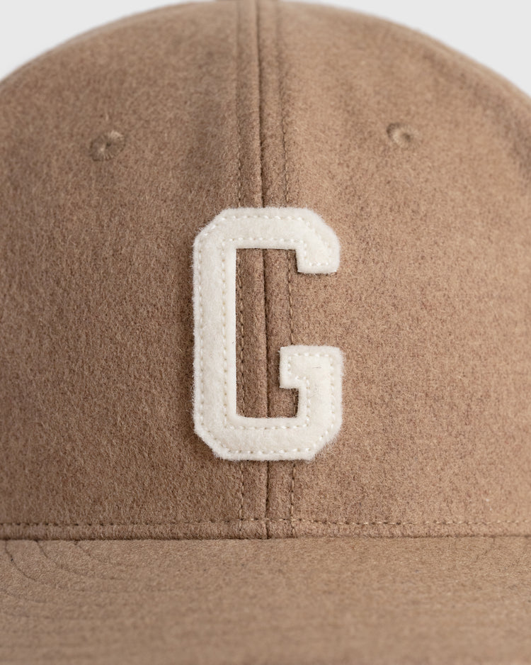 A close-up of the EFF Homestead Grays G Wool Ballcap, a vintage brown cap with a large white embroidered G on the front—paying tribute to Negro League memorabilia.