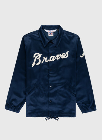 The EFF Atlanta Braves 1968 Satin Windbreaker Jacket is navy blue with “Braves” in white script, a “J” on the left sleeve, collar, snap buttons, front pockets, drawstring hem, and features the classic 1968 Braves logo.