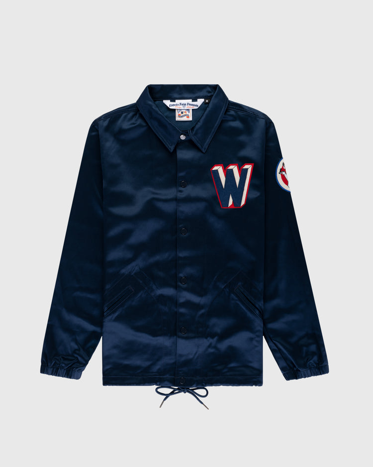 The EFF Washington Senators 1959 Satin Windbreaker Jacket is navy blue with two front pockets, a red and white “W” patch on the chest, a circular sleeve patch, collar, elastic cuffs, and a drawstring hem.