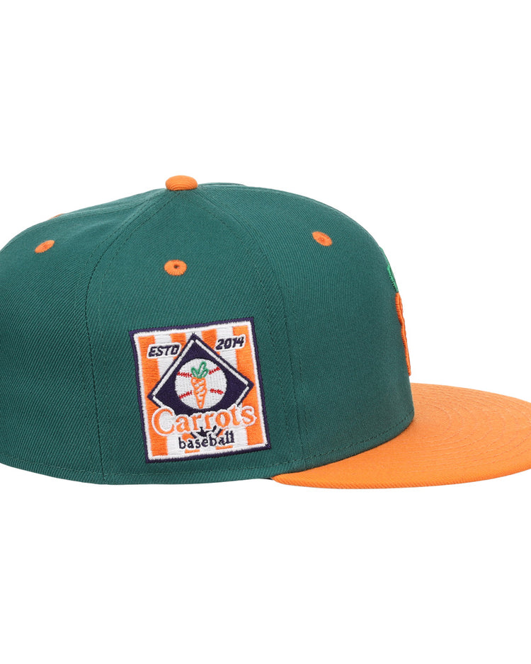 The EFF Carrots Arlington Heights Collection Logo Fitted Ballcap is a green cap with an orange brim and button, featuring a baseball patch with carrot graphic and ESTD 2014, plus a side carrot logo honoring the Arlington Heights Carrots legacy.